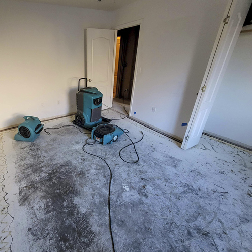 Water Damaged bedroom with carpet removed and air movers with a dehumidifier for drying Water Damage Restoration Clean Up In Alpharetta GA.